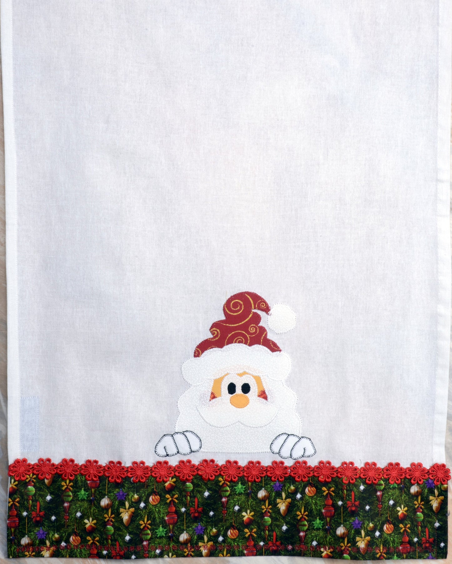 Tea Towel Santa peeking over Christmas trim.